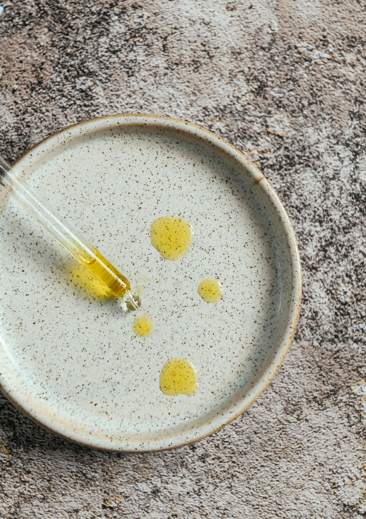 Niki Newd® Skin Velvet serum in a glass pipette – antioxidant oil serum with a rich golden tone that smooths and balances the skin.