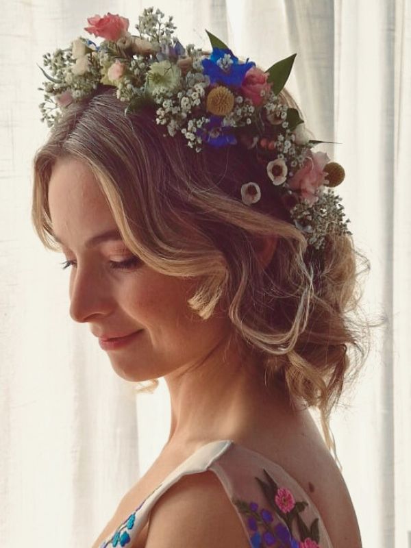 Romantic hairstyle with floral crown by Hair Studio Niki Newd® — soft curls and delicate flowers woven into the hair for an ethereal bridal look.